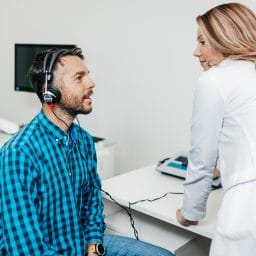 Middle age man at medical examination or checkup in otolaryngologist's office