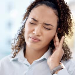 Woman with tinnitus holding her ear