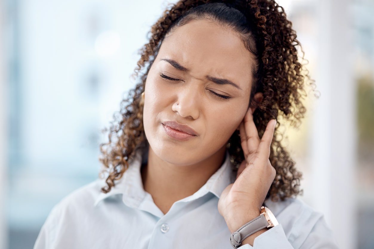Woman with tinnitus holding her ear