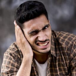 Man with a ringing sound in his ear, in pain.