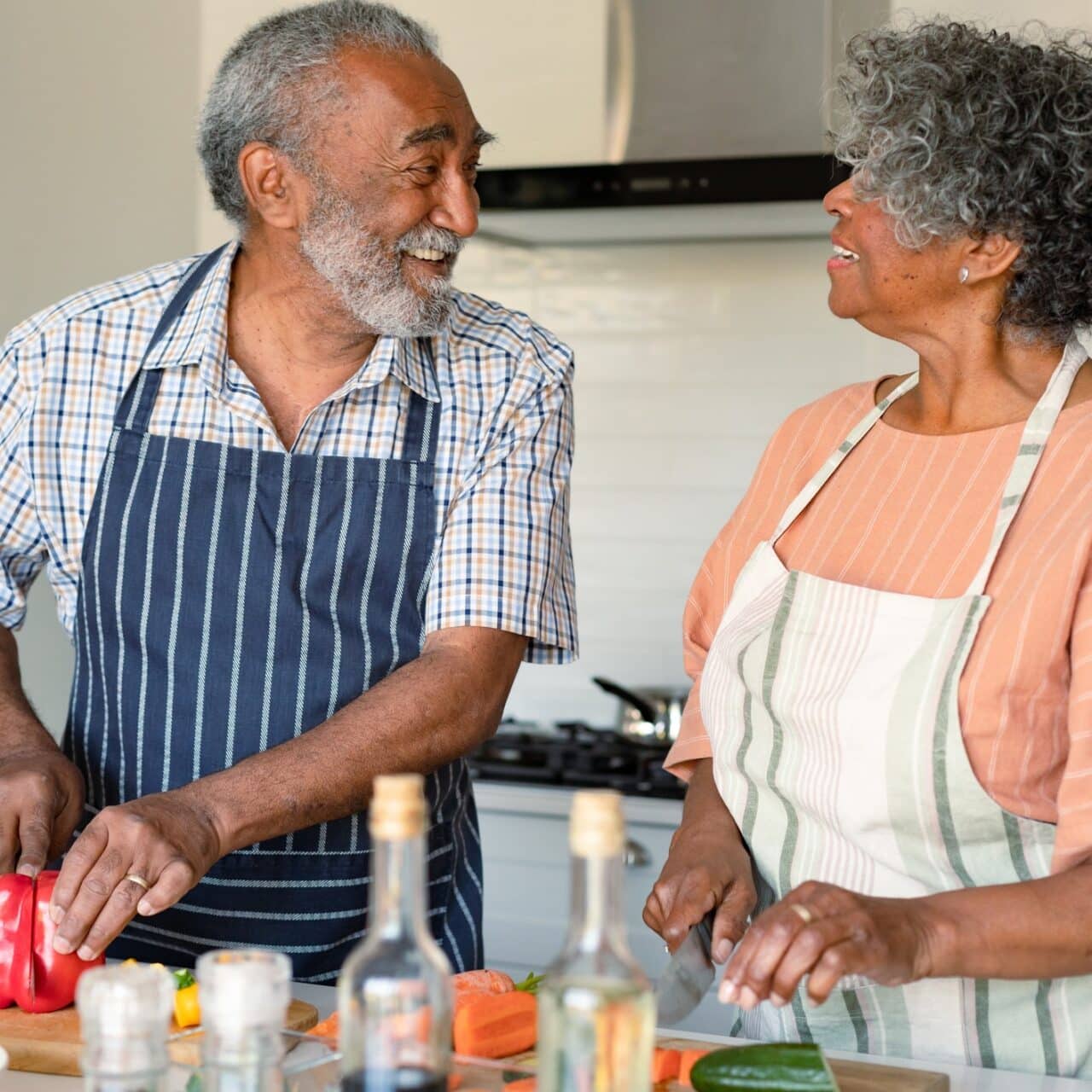 Happy couple in their kitchen cooking dinner together. 